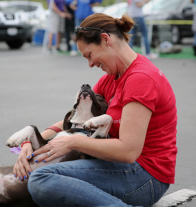 volunteer holding dog at rescue event